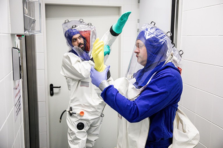 Scientists dress in full body protective suits before entering a biosafety level 4 lab in Hungary.