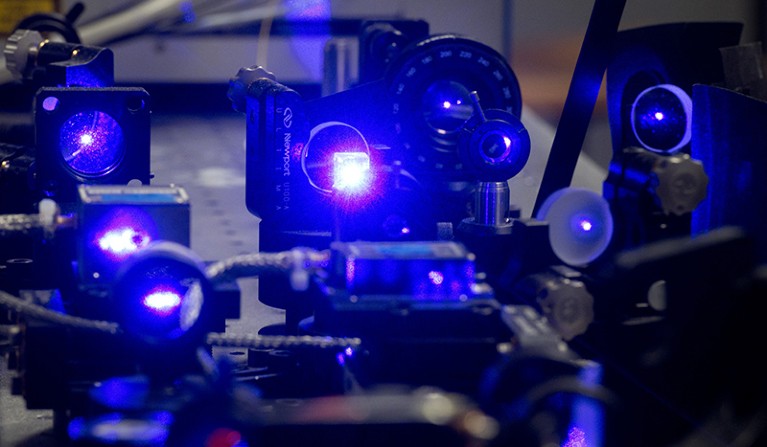 Blue laser light shines in a part of an optical clock in a laboratory at the Physikalisch-Technische Bundesanstalt in Germany.