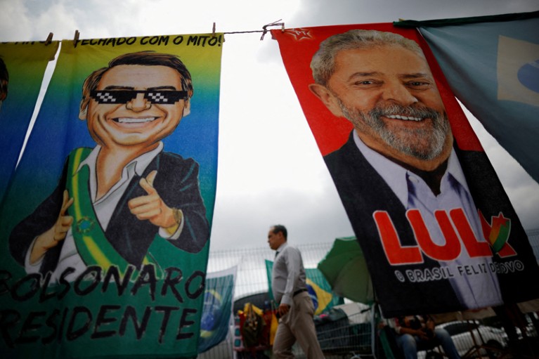 A man walks between two presidential campaign materials pegged to a line