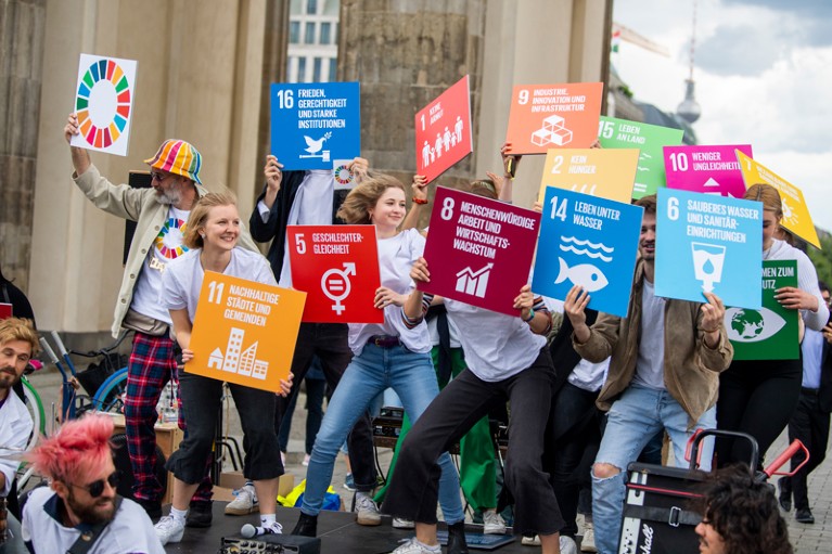 Participants of a demonstration stand with posters displaying the sustainable development goals