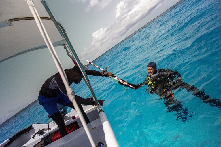 Henri Vallès dives next to a boat in Barbados to develop indicators for coral reef management.