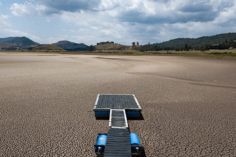 A jetty rests on the completely dry Suesca lagoon experiencing extreme drought