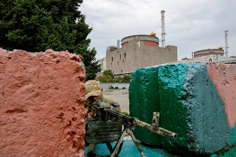 A service member levels a weapon at a checkpoint near the Russian-controlled Zaporizhzhia Nuclear Power Plant in Ukraine, 2022.