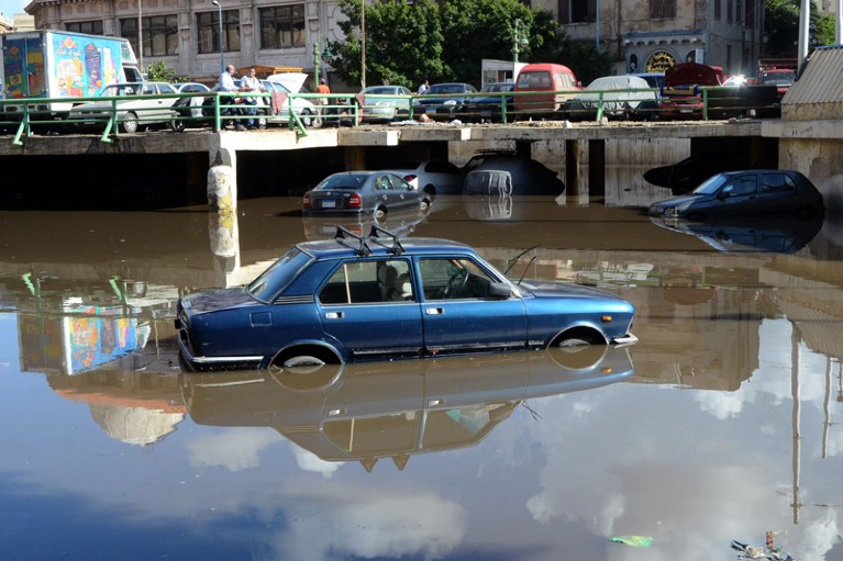 A blue car is submerged in flood water caused by rainy weather in the city of Alexandria