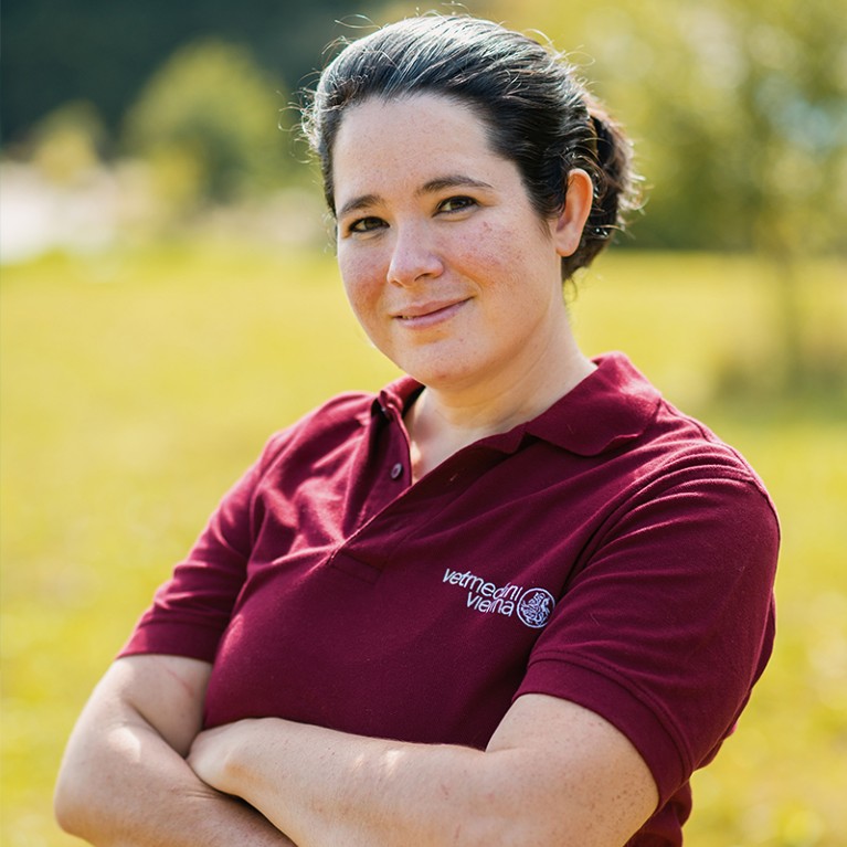 Jennifer Colbourne standing outside on the grounds of her PhD lab in Austria.