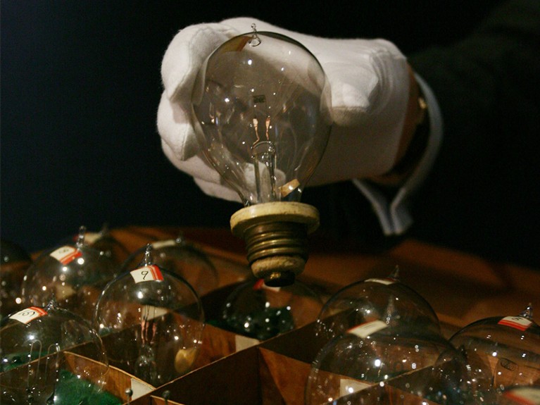 A specialist in mechanical music at Christie's holds one of the light bulbs which was used as evidence during Edison trial.