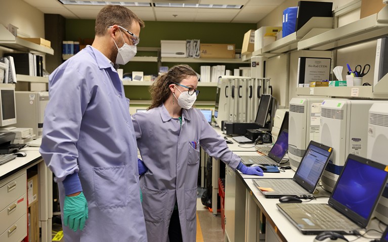 Research Scientists, Dr. Alex Greninger (L) and Dr. Margaret Mills, discuss PCR curves while testing for the Monkeypox virus.