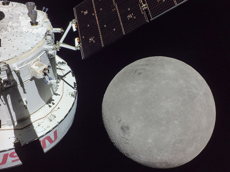 The far side of the Moon looms large to the right of the spacecraft.