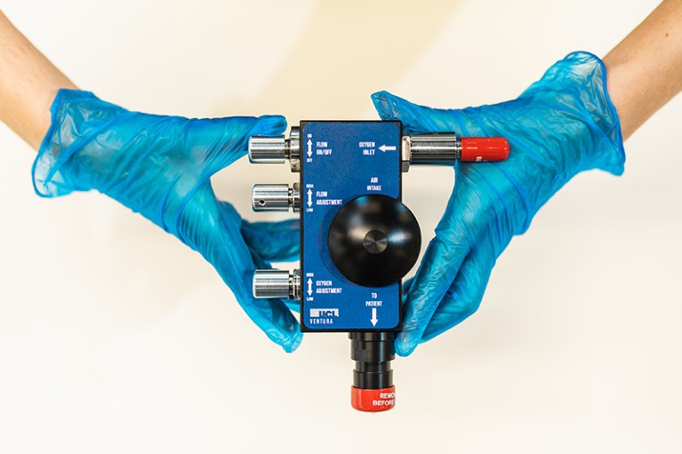 Gloved hands holding a Ventura breathing aid