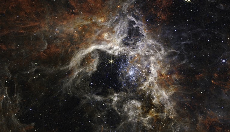 Tarantula Nebula star-forming region shows tens of thousands of young stars that were previously shrouded in cosmic dust.