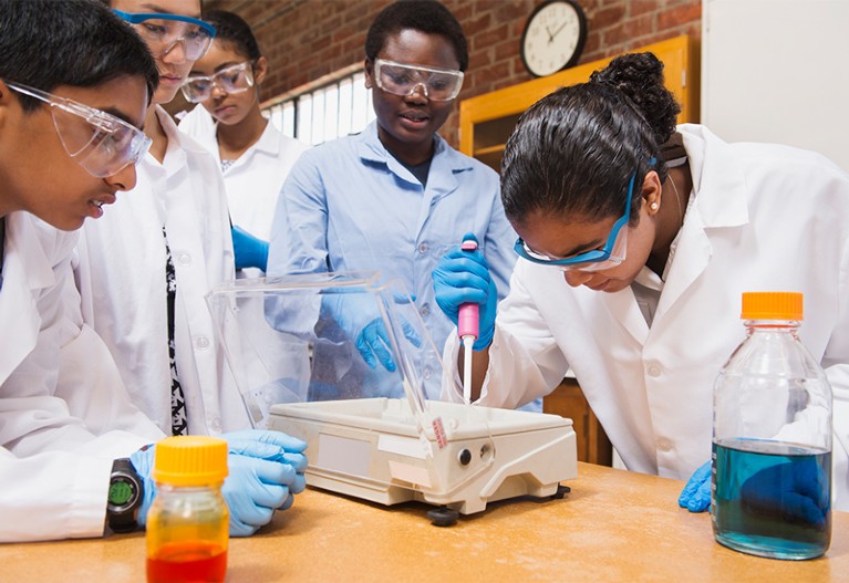 Teacher and students working in science lab.