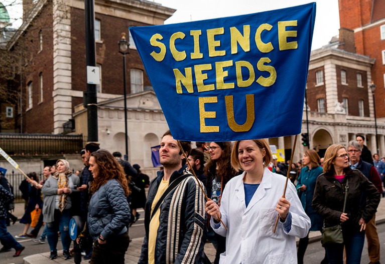 A protester holds a "Science needs EU" banner on a march against Brexit and pro second referendum, London.