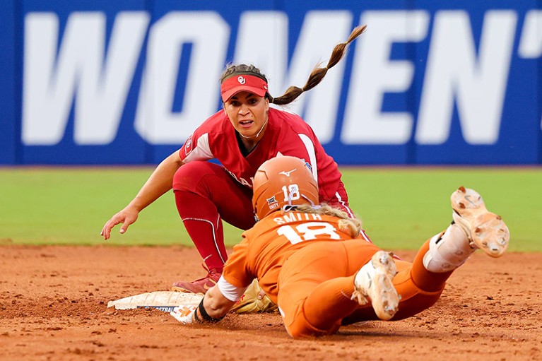 Softball player Grace Lyons of the Oklahoma Sooners tags out JJ Smith of the Texas Longhorns as she slides into the base