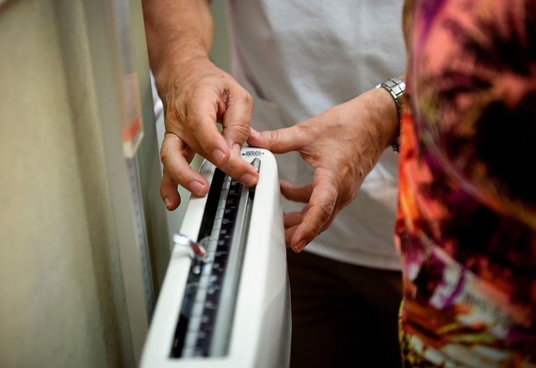 Doctor Carlos Pineiro weighs a woman at the town's health center in Naron, on September 13, 2018.