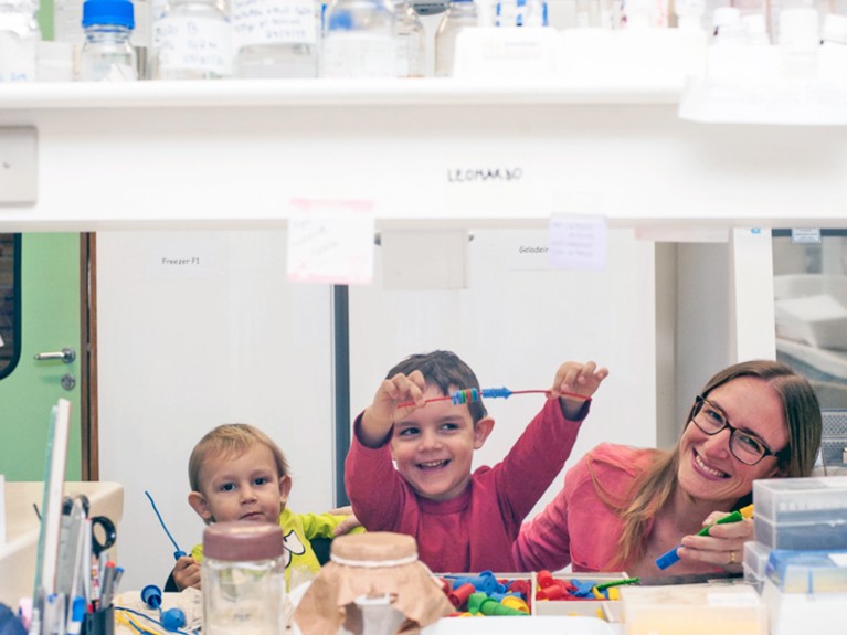 Fernanda Staniscuaski in the lab wih her two sons who are playing a game to assemble proteins.