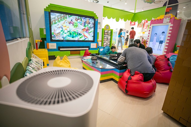 Children and a parent play in a room with an air purifier at a kids' cafe inside a shopping mall in Seoul, South Korea, 2019.
