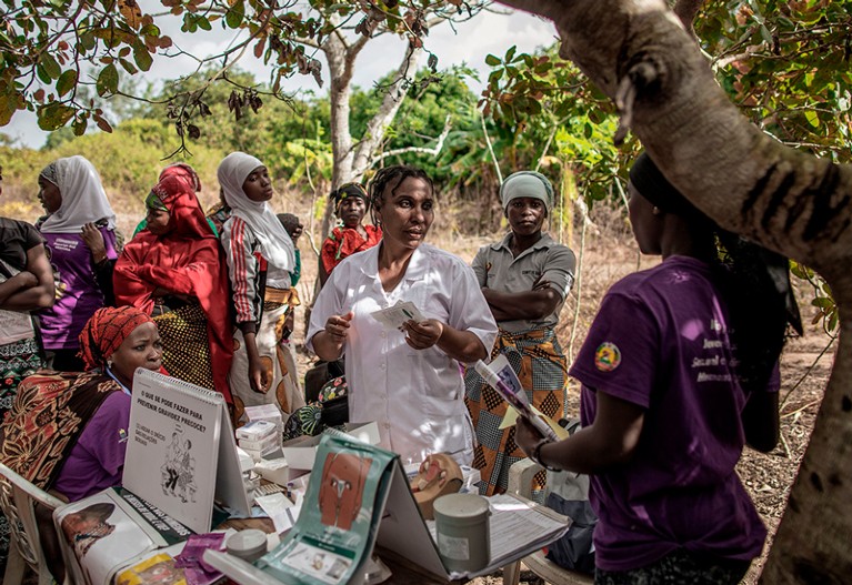 一名莫桑比克护士在健康点聚会上与当地妇女交谈。