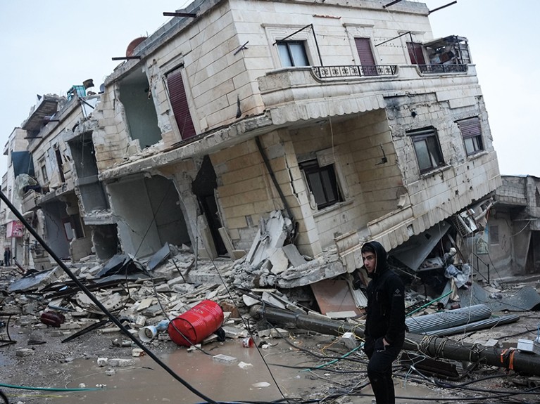 Residents in front of a collapsed building.