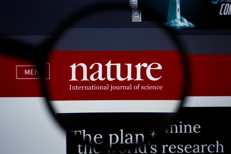 一台电脑屏幕上的放大镜盘旋在《自然国际》科学杂志的标志上