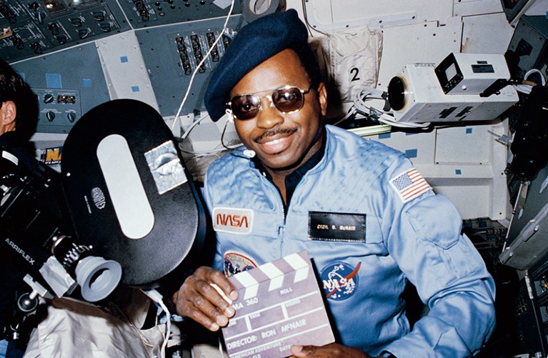 Astronaut Ronald McNair directs a movie from the Earth-orbiting Space Shuttle Challenger.