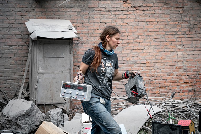 Kseniia Minakova in rubble after a Russian bombing, saving what she can of the lab,