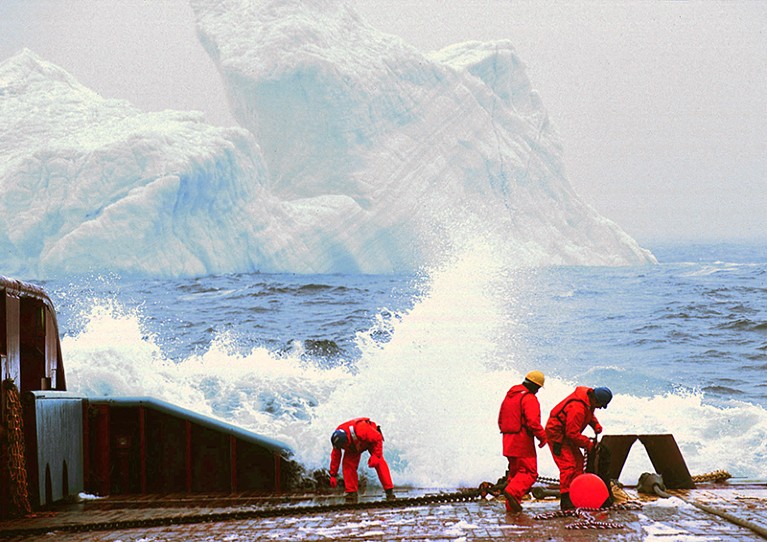 Workers on a ship battle high seas while trying to attach tow cables to a 150,000 ton iceberg near Newfoundland, in 1998.