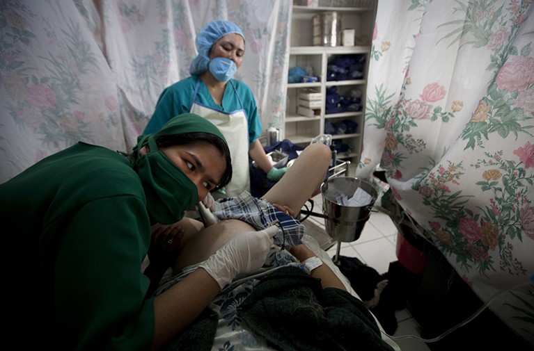阿富汗巴米扬，一名助产士学生在医院的产房里倾听一名产妇的心跳。