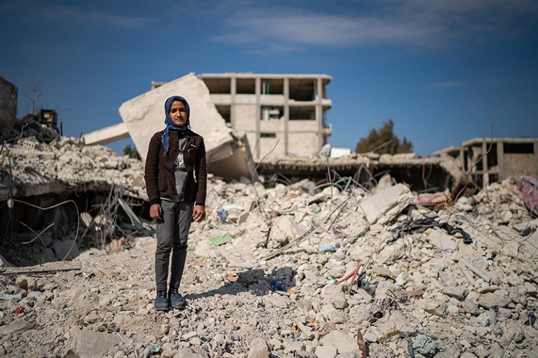Mezyan Abdulhamed Mohamed, 12, pictured amongst destroyed buildings in the town of Jindires, Syria