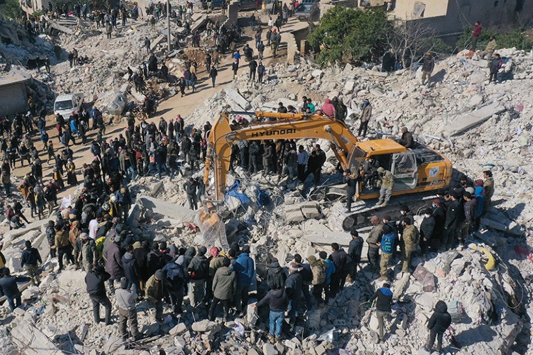 Aerial view of rescuers searching for survivors amidst the rubble of a collapsed building in the town of Harim in Syria.