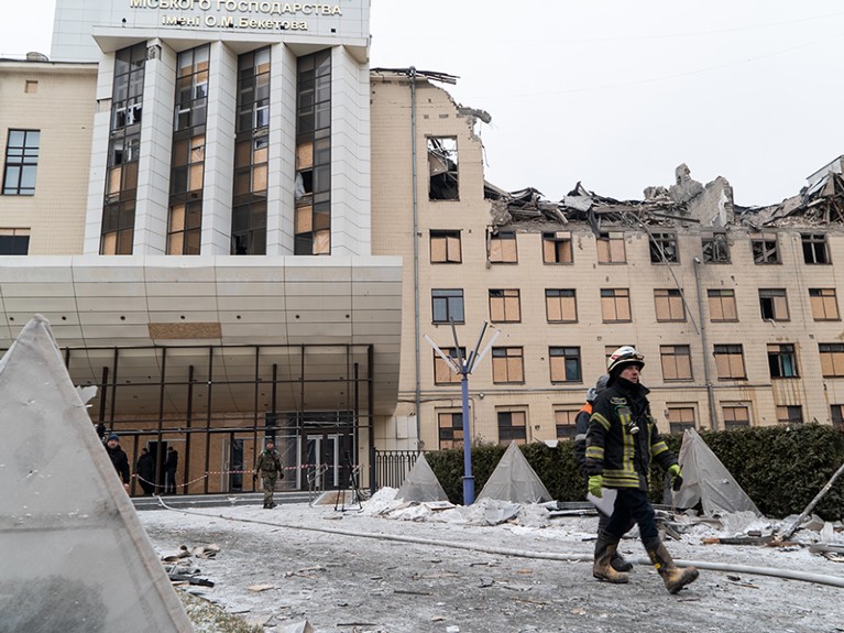 2023年2月5日，乌克兰哈尔科夫，救援人员在受损的大学大楼前的废墟中行走。