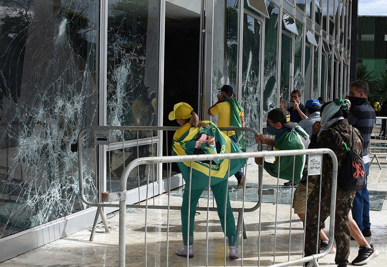 身穿巴西国旗和支持博尔索纳罗横幅的支持者摧毁了巴西利亚最高法院大楼的窗户