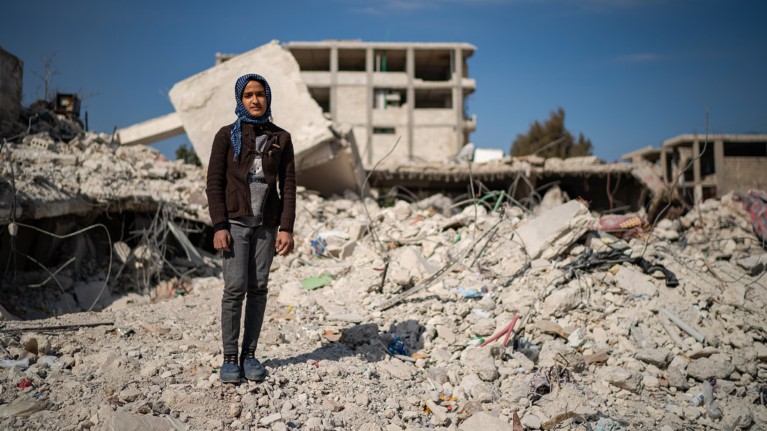 Mezyan Abdulhamed Mohamed, 12, pictured amongst destroyed buildings in the town of Jindires, Syria