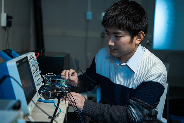 Yuuki Wada seated in lab using equipment