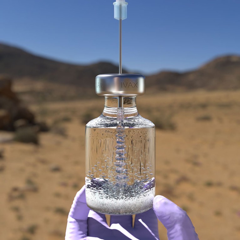 A gloved hand holds a vial containing liquid into which a needle has been inserted