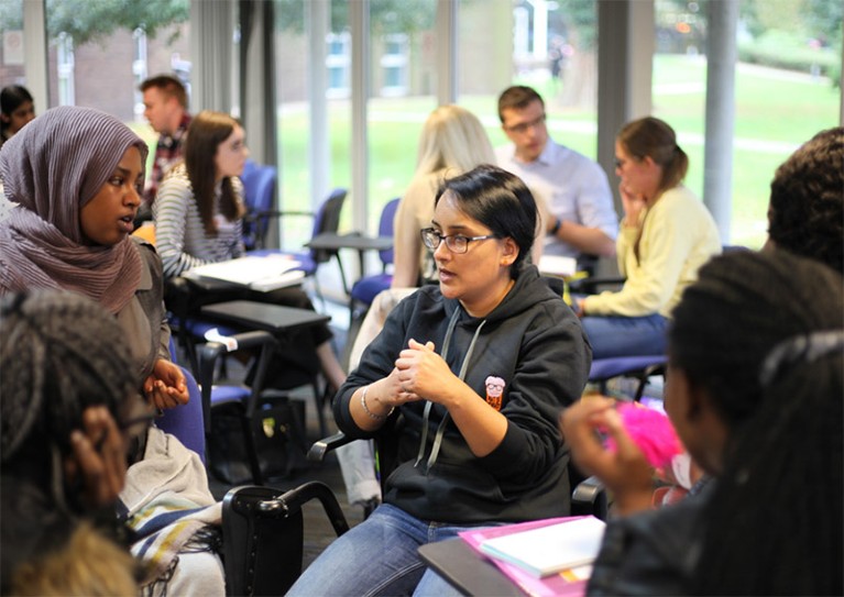 Pint of Science co-founder Praveen Paul talking with students in an informal setting at the University of Northampton.