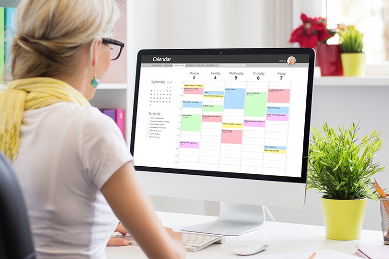 Woman using calendar application on computer in office