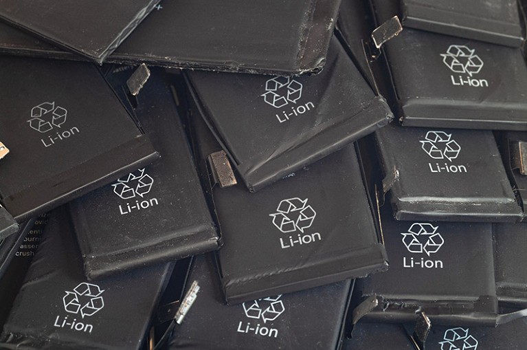 Close up of old used lithium mobile phone batteries in black casing with recycle symbol and Li-ion printed on the front