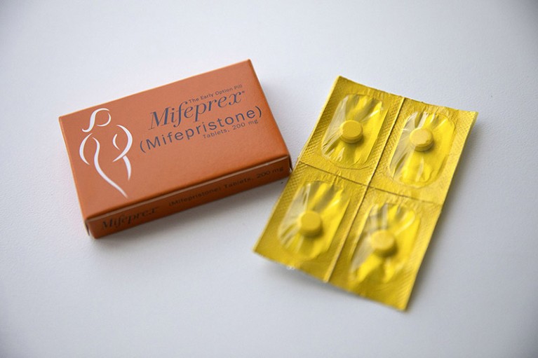 Mifepristone and misoprostol pills isolated on a white table.