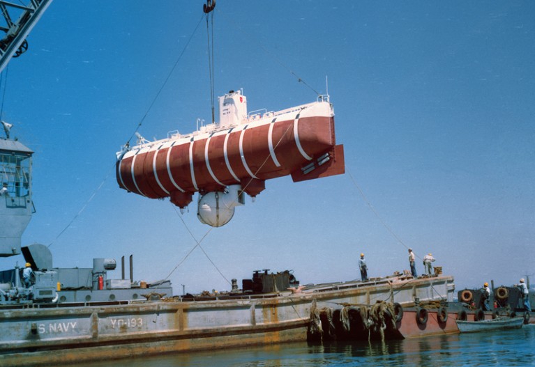 A crane raises the Trieste bathyscaphe.