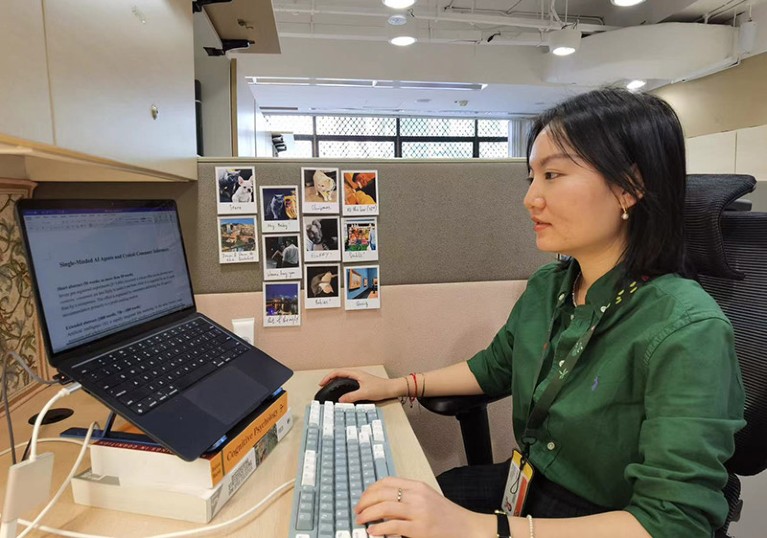 Sijin Chen sat working at a laptop in an office environment