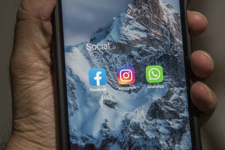 Facebook, Instagram, and Whatsapp icons on a mobile phone's screen.