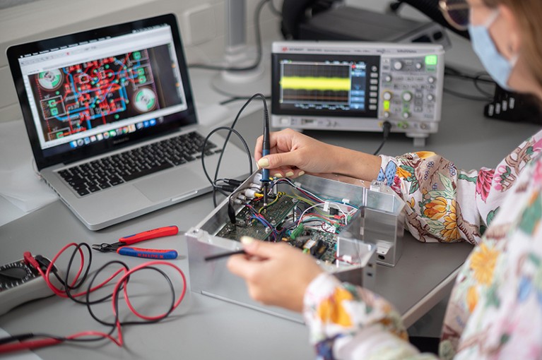 In a laboratory of the technology company Qant, a woman shows a voltage measurement on a quantum sensor.