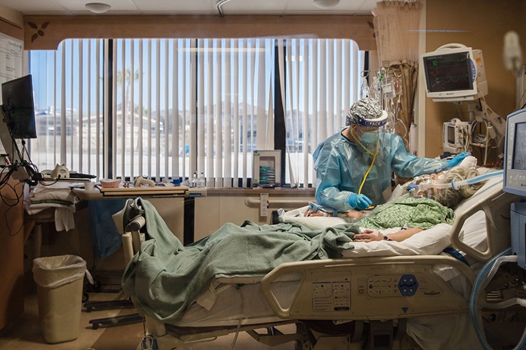 A nurse tends to a patient with COVID-19 in an intensive care unit.