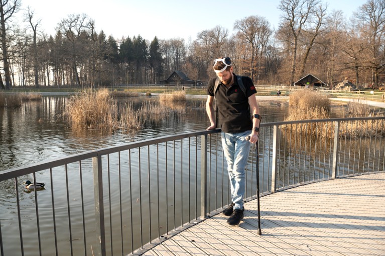 Un paziente cammina all'aperto vicino a un lago con un ponte digitale