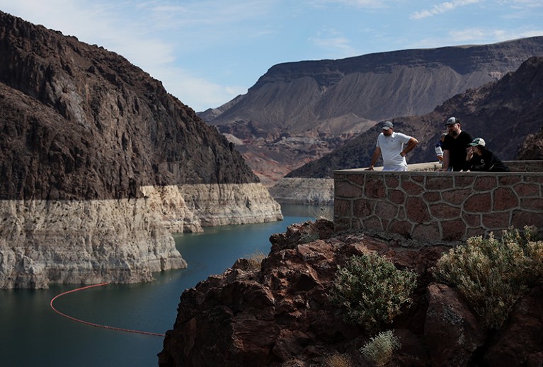 Park visitors look at a bleached 'bathtub ring' that is visible on the banks of Lake Mead near the Hoover Dam.