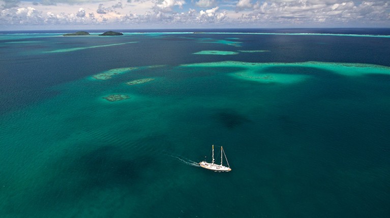 Drone view of the ship Tara in green waters of the Wallis lagoon.