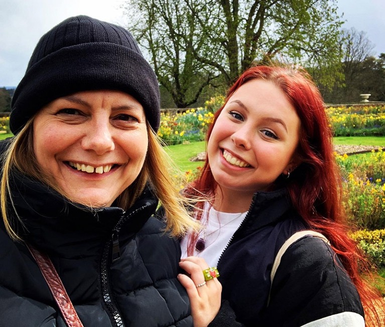 Selfie of Claire and her daughter Tory smiling with a public garden visible in the background