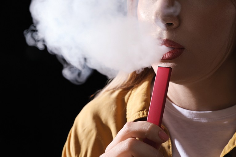 A person exhaling smoke from an e-cigarette.