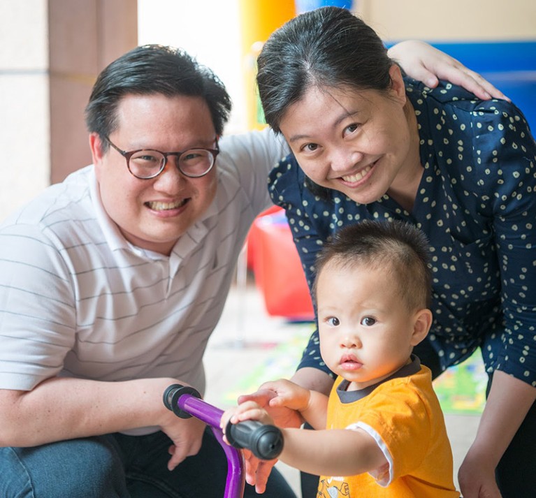 Happy family portrait of Valerie Shiwen Yang with her husband and toddler