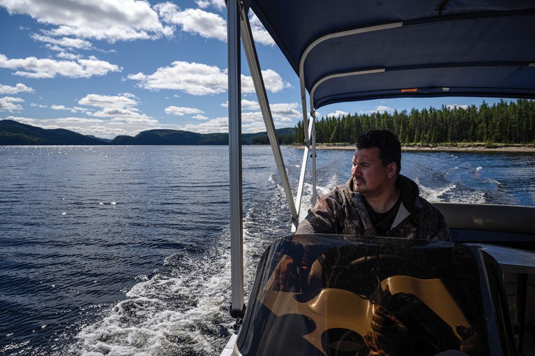 Innu caribou researcher Jean-Luc Kanapé steers his boat through a waterway in the Canadian boreal forest in the Québec Province.